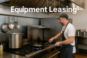A business owner cooks with leased equipment in a commercial restaurant kitchen.